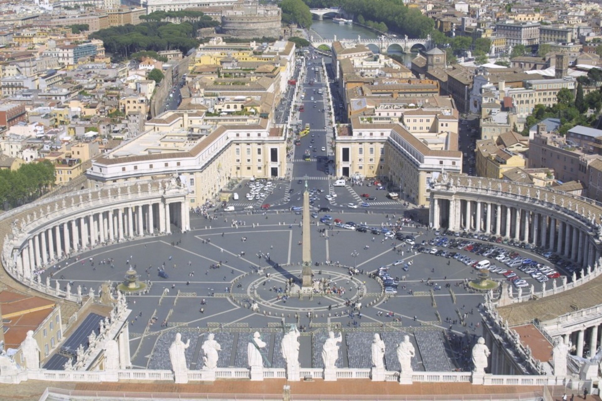 Ilustracja przedstawia Plac Świętego Piotra w Watykanie z lotu ptaka. Plac Świętego Piotra ma formę elipsy otoczonej dwoma rzędami kolumn. Pośrodku placu znajduje się egipski obelisk Amenemhata II ku czci boga słońca. Na szczycie obelisku umieszczono krzyż symbolizujący zwycięstwo chrześcijaństwa nad pogaństwem. Po obu stronach obelisku stoją dwie fontanny.