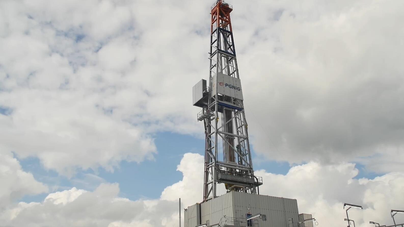 Na zdjęciu widoczny jest wieżomaszt. Wieżomaszt jest konstrukcją kratową przypominającą kształtem literę A. Widoczny na zdjęciu wieżomasz składa się z dwóch poziomów. Na dolnym pokładzie znajduje się duża szara obudowa wykonana z blachy falistej. Po prawej stronie wieżomasztu znajduje się drabina prowadząca na górny poziom. Środkiem wieżomaztu biegnie rura wydobywcza.Wieżomaszt jest na tle nieba.