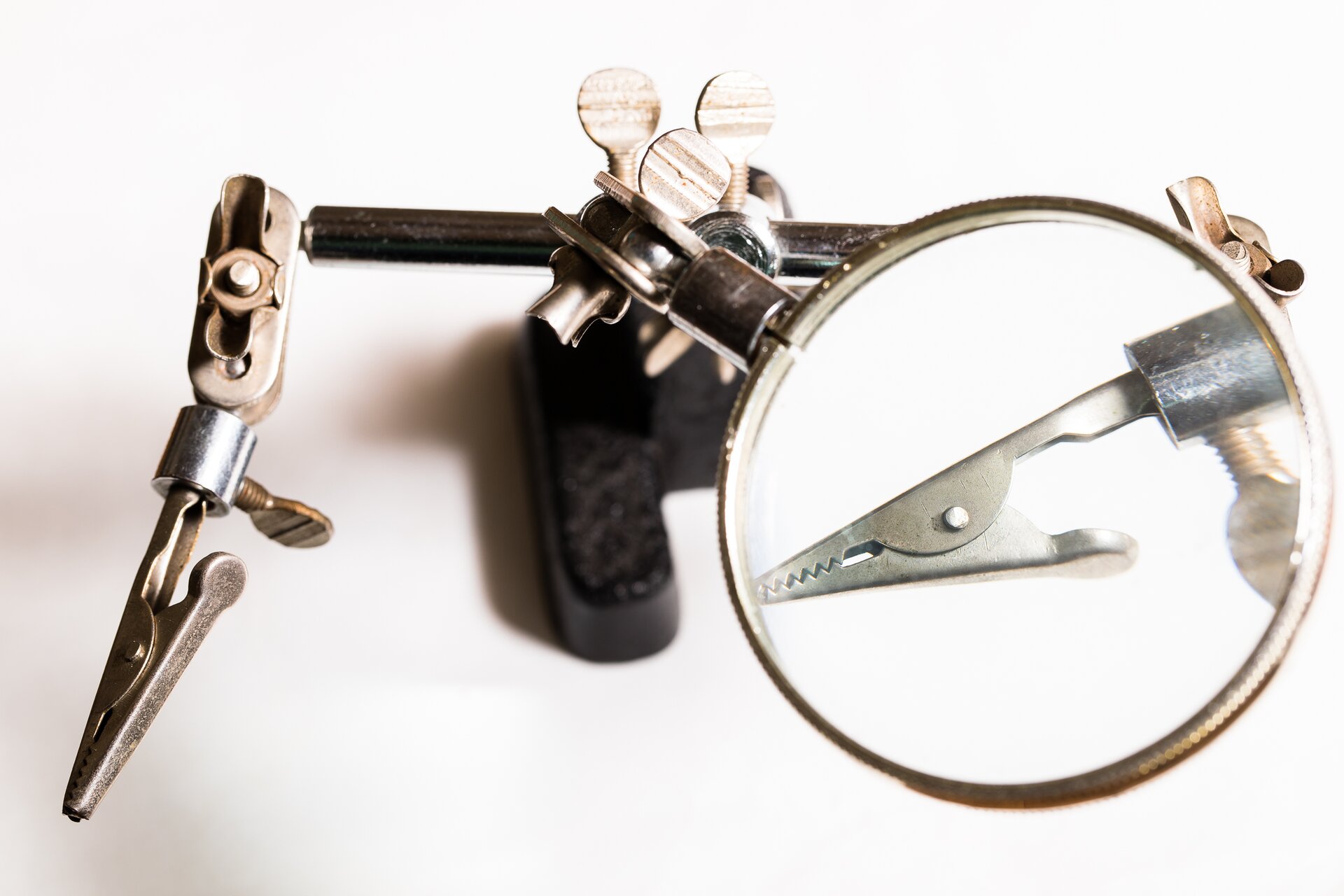 Zdjęcie przedstawia stojak z 2 klipsami do trzymania podzespołów oraz 3 dodatkiem jakim w tym przypadku jest szkło powiększające.