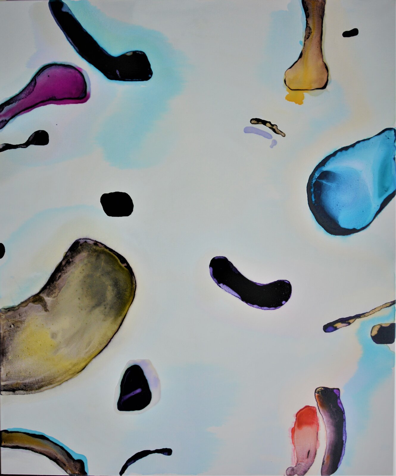 Ilustracja przedstawia obraz „Cząstki elementarne”, autorstwa Krzysztofa Pituły. Artysta, przy pomocy nieregularnych, obłych kształtów stworzył abstrakcyjną, otwartą kompozycję na białym tle. Każdy z elementów obrazu umieszczony jest oddzielnie, unosi się jakby bezwładnie w przestrzeni obrazu. Większość z nich wychyla się jakby zza kadru. Cztery małe, ciemne kształty znajdują się w centrum. Tło podmalowane jest delikatnie rozmytą, błękitną farbą. W kompozycji dominuje biel, czerń i błękit, gdzieniegdzie artysta użył również barwy żółtej, czerwonej i ciemnego różu.