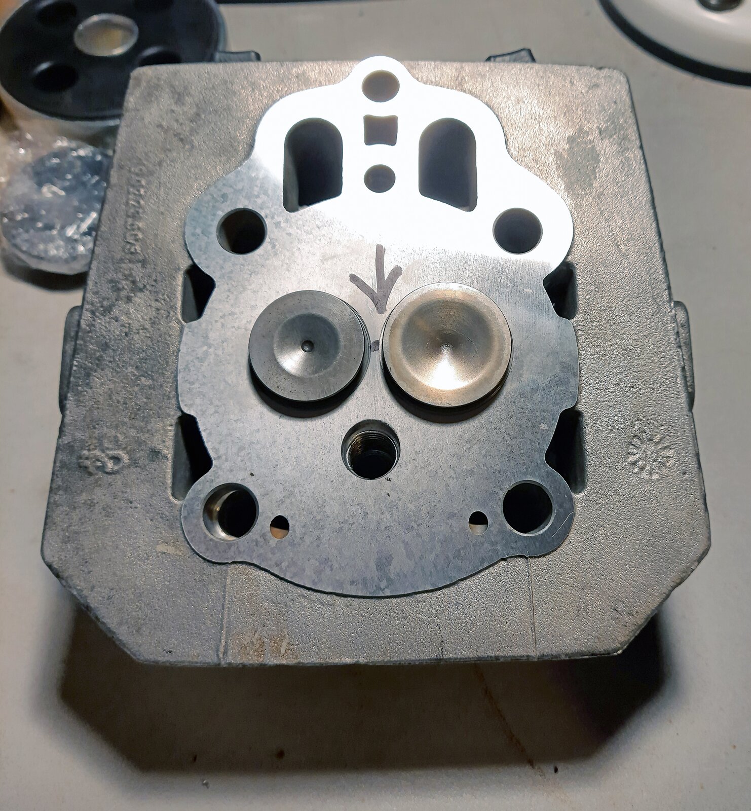 Na ekranie zbliżenie na małe pęknięcie pomiędzy gniazdami zaworowymi ujawnione dzięki procesowi planowania głowicy.