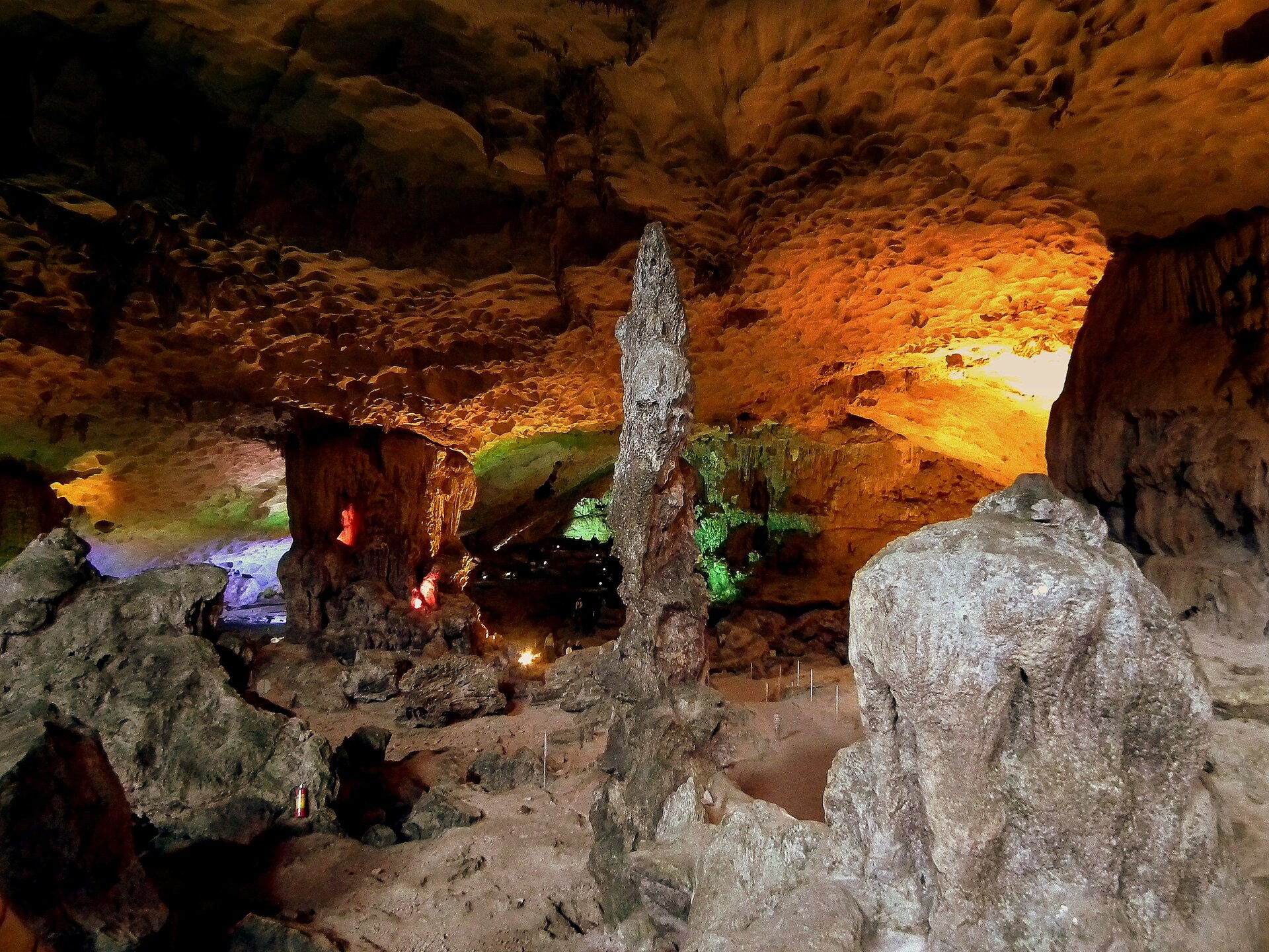  Na fotografii po prawej stronie jest niewysoka i szeroka skała. Obok niej na środku wznosi się wysoka, cienka skała naciekowa. Za skałami znajduje się wnętrze jaskini i inne skały wystające z podłoża. Całość trzyma się na dwóch masywnych słupach skalnych. Jaskinia jest oświetlona lampami w różnych kolorach. 