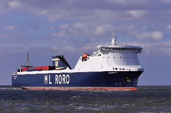 Zdjęcie przedstawia statek ro‑ro. Statek przewozi samochody przez rzekę. Na burtach znajdują się słupy podtrzymujące powyżej pokładu sterówkę.