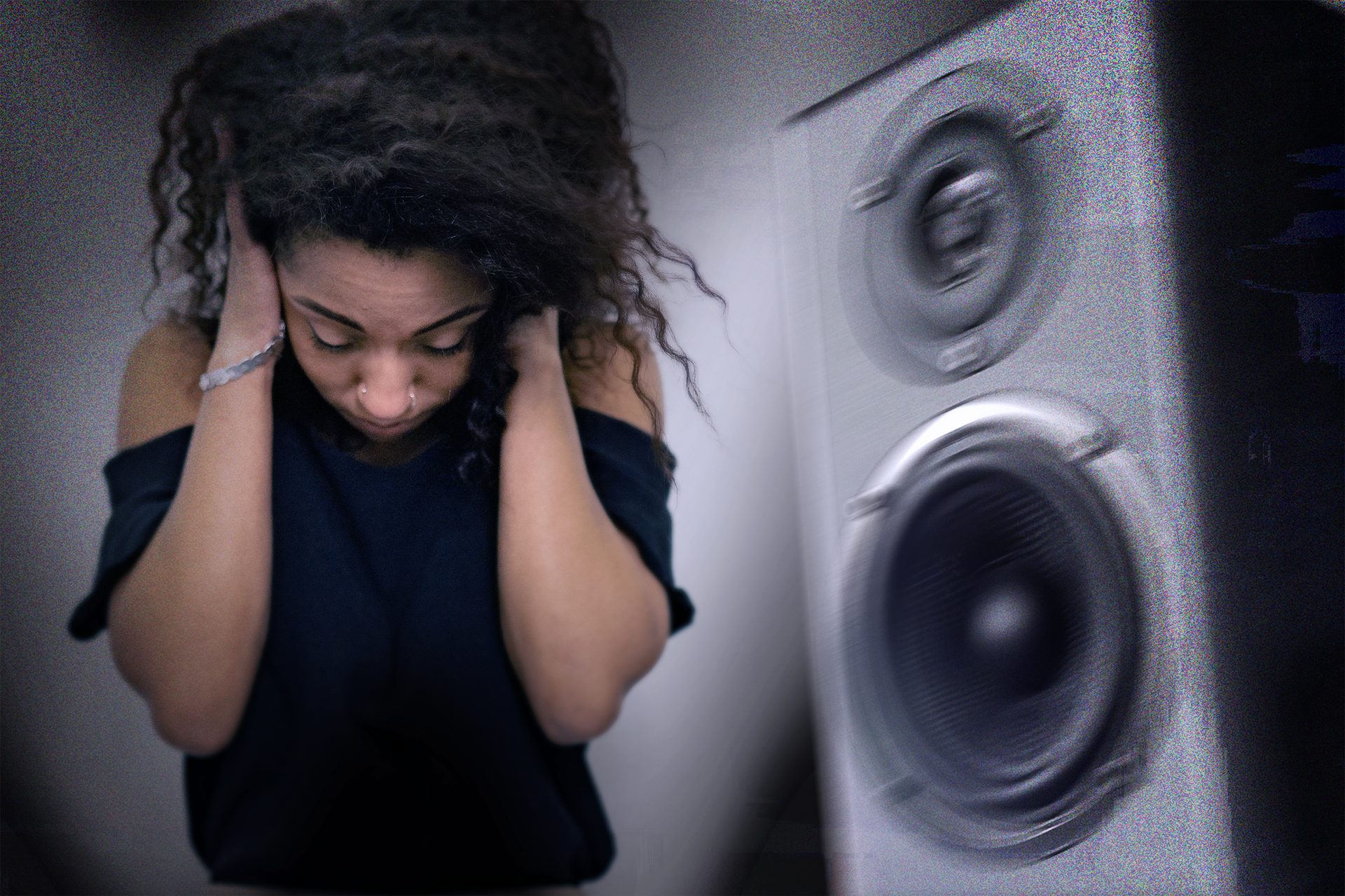 Ilustracja przedstawia kompozycję fotograficzną przygotowaną na potrzeby kampanii zwalczania hałasu. W lewej części młoda kobieta w czarnej bluzce z rozczochranymi włosami zaciska uszy rękoma. Po prawej stronie duży głośnik skierowany w stronę kobiety. Cały obraz jest rozmyty, co ma symbolizować drgania spowodowane głośnymi dźwiękami.