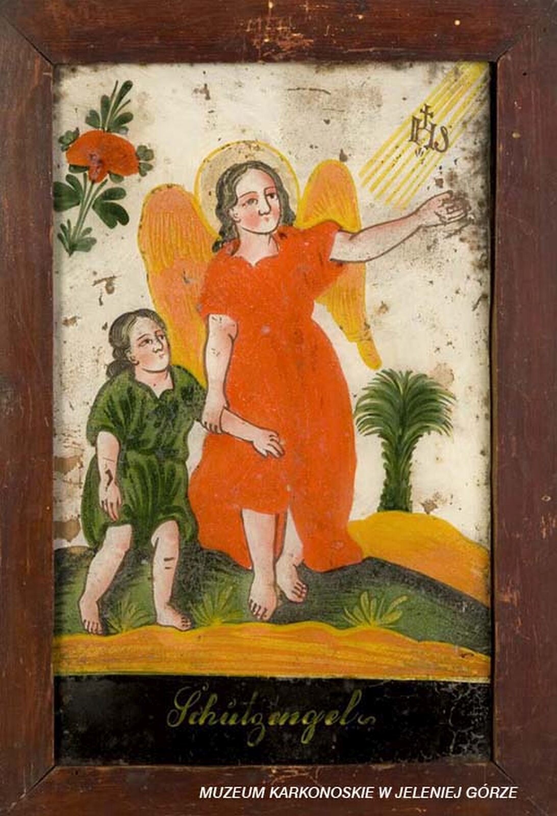 Ilustracja przedstawia malowidło na szkle, które ukazuje anioła prowadzącego za rękę dziecko. Anioł ma pomarańczową szatę, a lewą ręką wskazuje na promienie boskie z napisem IHS. Dziecko jest ubrane w zieloną szatę. W tle widać drzewo palmowe i czerwony kwiat.