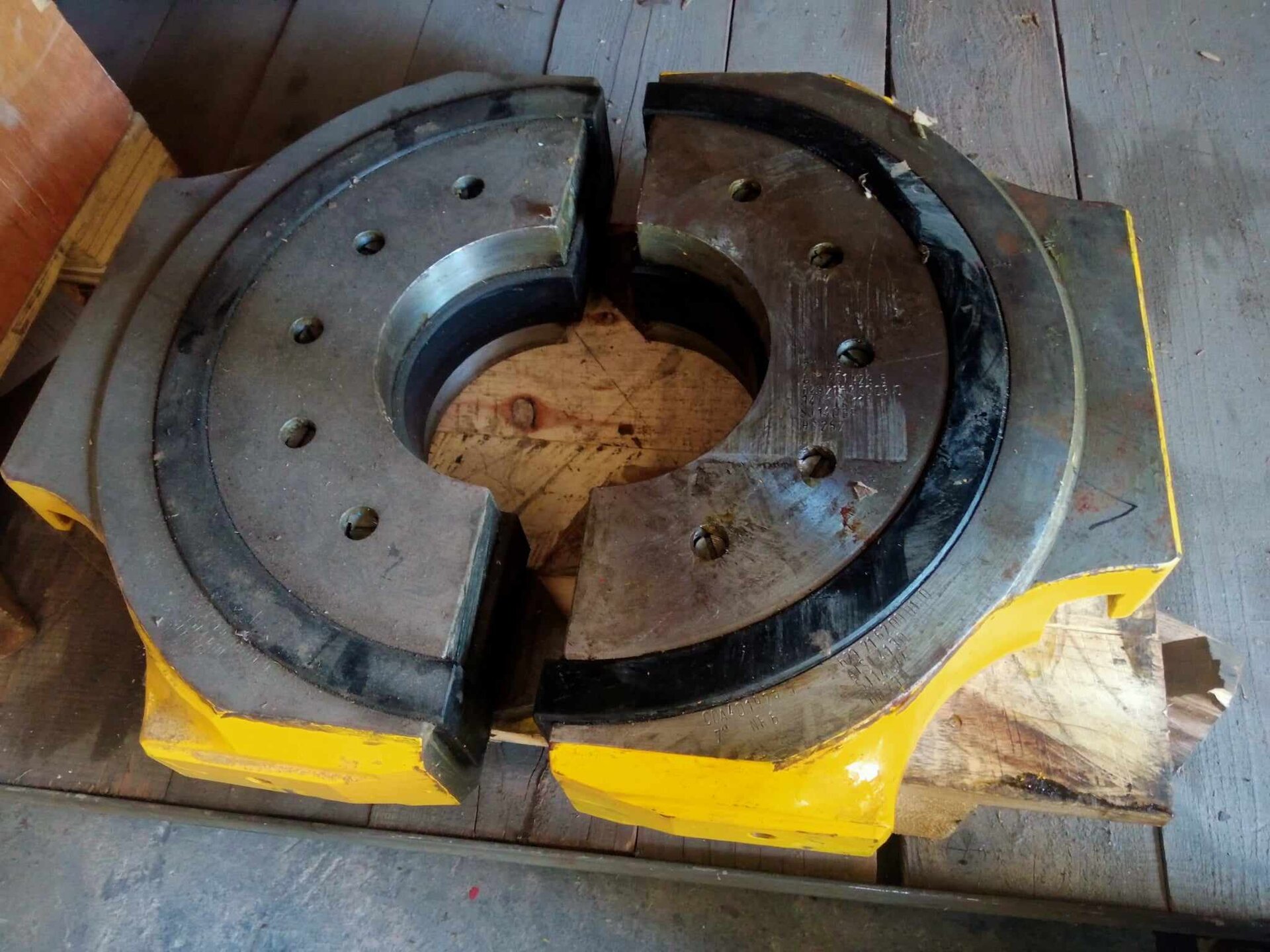 Na zdjęciu widoczne są szczęki na przewód. Szczęki służą do zaciśnięcia przewodu wiertniczego. Szczęki są w kształcie metalowego koła z wyciętym okrągłym środkiem. Wewnątrz metalowego zacisku znajduje się inny materiał. Na kole znajduje się pięć otworów na śruby. Koło jest otoczone większym okręgiem z innego materiału. Koło przedzielone jest w połowie. Zewnętrzna warstwa szczęk jest metalowa i jest koloru żółtego.