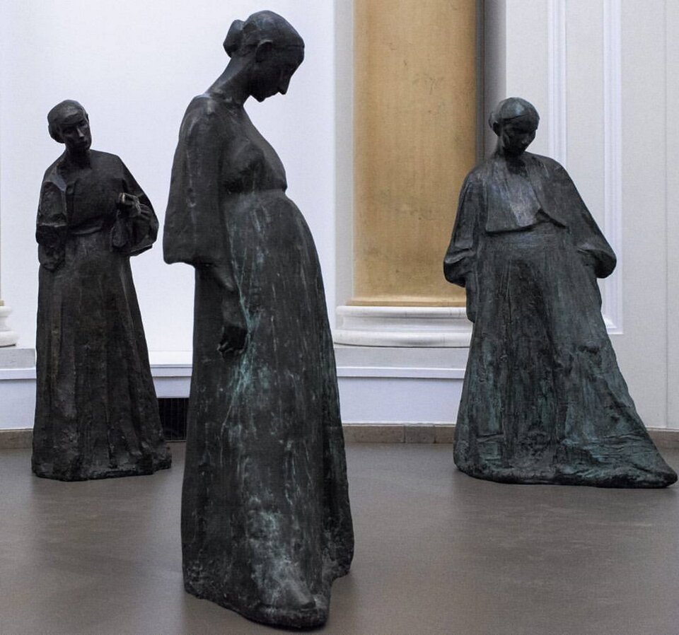 Ilustracja przedstawia rzeźbę pt. „Kobiety brzemienne” autorstwa Xawerego Dunikowskiego. Rzeźba ukazuje trzy brzemienne kobiety.