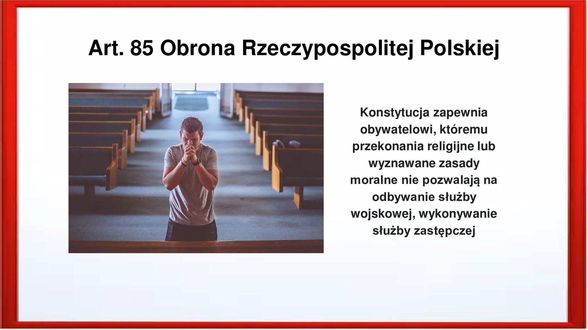 Slajd otoczony jest czerwoną ramką. Wewnątrz znajduje się napis tytułowy: Art. 85 Obrona Rzeczypospolitej Polskiej. Po lewej stronie jest zdjęcie, które przedstawia modlącego się mężczyznę. Klęczy on na kolanach, dłonie ma złożone. Za nim są ustawione w dwóch rzędach ławki. Po prawej stronie jest zamieszczony napis: Konstytucja zapewnia obywatelowi, któremu przekonania religijne lub wyznawane zasady moralne nie pozwalają na odbywanie służby wojskowej, wykonywanie służby zastępczej.