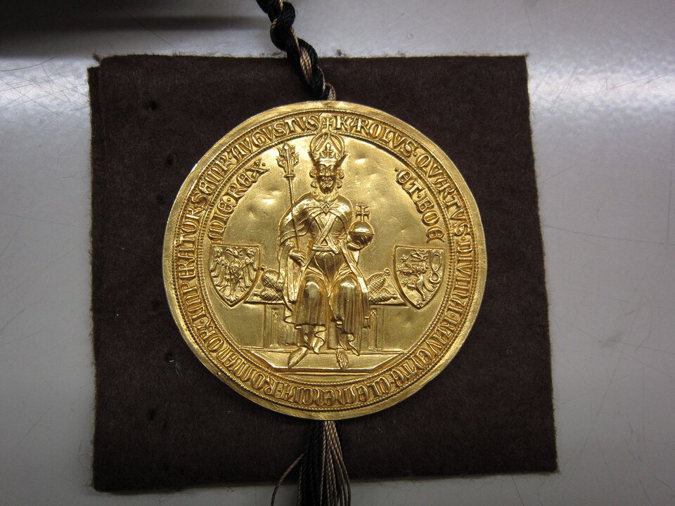 Ilustracja przedstawia przód cesarskiej pieczęci. Na pieczęci uwieczniona jest postać władcy siedzącego na tronie. Ubrany jest w powłóczyste szaty, na głowie ma koronę z krzyżem na szczycie, a w rękach berło i jabłko z krzyżem. Po obu stronach postaci znajdują się herby – jeden z wizerunkiem orła z rozłożonymi skrzydłami, drugi z postacią lwa stojącego na tylnych łapach. Na krawędziach pieczęci znajdują się napisy w języku łacińskim.  