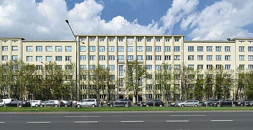 Siedziba Ministerstwa Klimatu i Środowiska w Warszawie. Budynek Ministerstwa Klimatu Środowiska w Warszawie - jasna, wielokondygnacyjna siedziba z dwoma skrzydłami i przeszklonym wejściem.