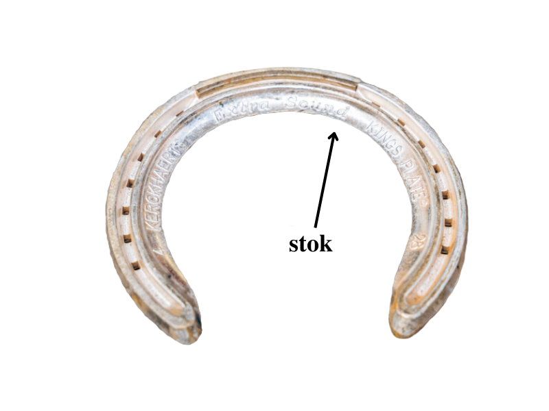 Na zdjęciu widoczna jest podkowa wygięta w kształt litery U. Przednia część podkowy jest nieco węższa niż tylna. Spód podkowy jest łukowaty, a przez środek prowadzi wgłębienie. Po każdej stronie podkowy znajduje się siedem prostokątnych otworów na gwoździe. Od wewnętrznej strony widoczne są również napisy producenta i wymiary. Zaznaczony został stok, który znajduje się w miejscu wygięcia podkowy.
