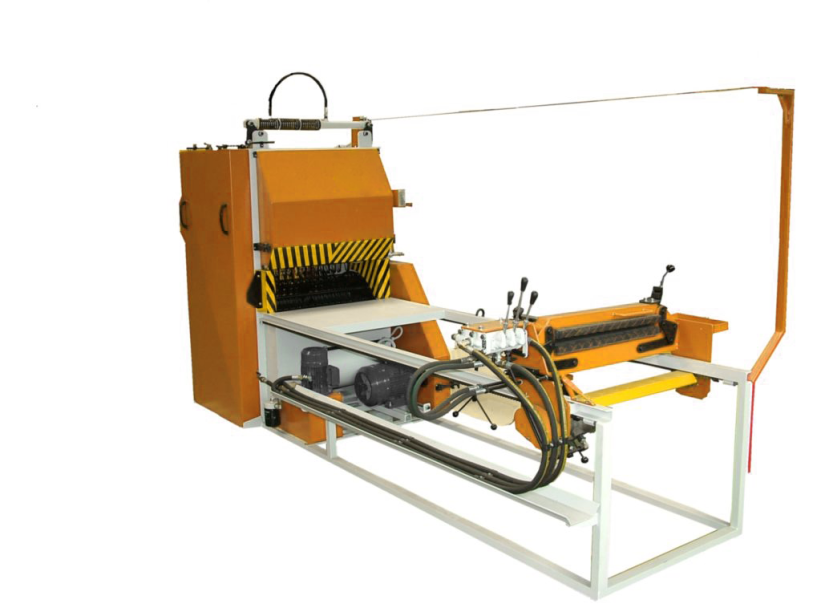 Zdjęcie przedstawia korowarkę mechaniczną. Urządzenie składa się z metalowej obudowy, stołu i panelu sterującego z dźwigniami. 