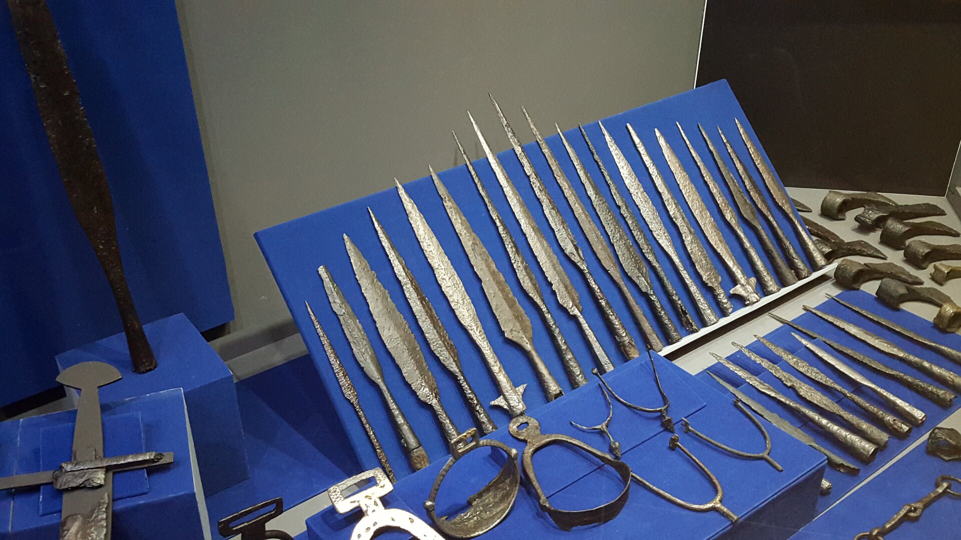 Zdjęcie przedstawia ostrza włóczni ułożone na wystawie.