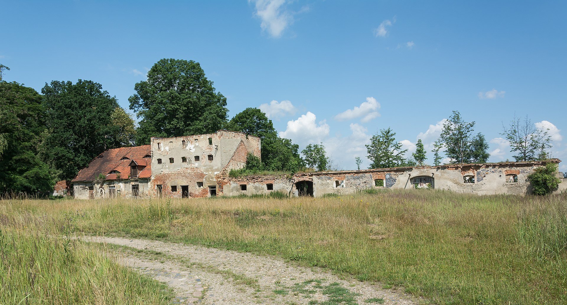 Ilustracja przedstawia osadę folwarczną w Kalinowicach Górnych, woj. Dolnośląskie. Budynki pełniły rolę muru dookoła wsi. 