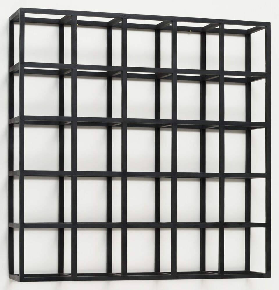 Zdjęcie przedstawia kompozycję pod tytułem: „Kubiczna modułowa, czarna konstrukcja ściany”, autorstwa Sol LeWitt. Na fotografii znajduje się nowoczesna rzeźba, złożona z 25 takich samych sześcianów. Sześciany ułożone są naprzeciwko siebie tworząc jeden duży sześcian. Sześciany składają się z czarnych prętów. Czarna konstrukcja umiejscowiona jest na białym tle.  