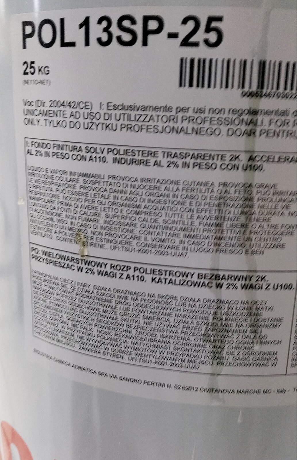 Zdjęcie przedstawia fragment cylindrycznego, białego pojemnika na lakier poliestrowy. Pośrodku pojemnika widoczna jest etykieta z napisami i kodem kreskowym.