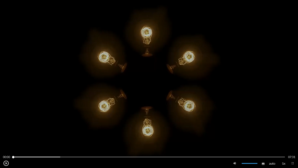 Ilustracja przedstawia ekran startowy filmu. Widoczna jest ilustracja przedstawiająca ułożone w kręgu włączone żarówki. Poniżej znajduje się pasek odtwarzania, a na dole funkcje takie jak regulacja głośności, przyspieszenie, tryb pełnoekranowy.