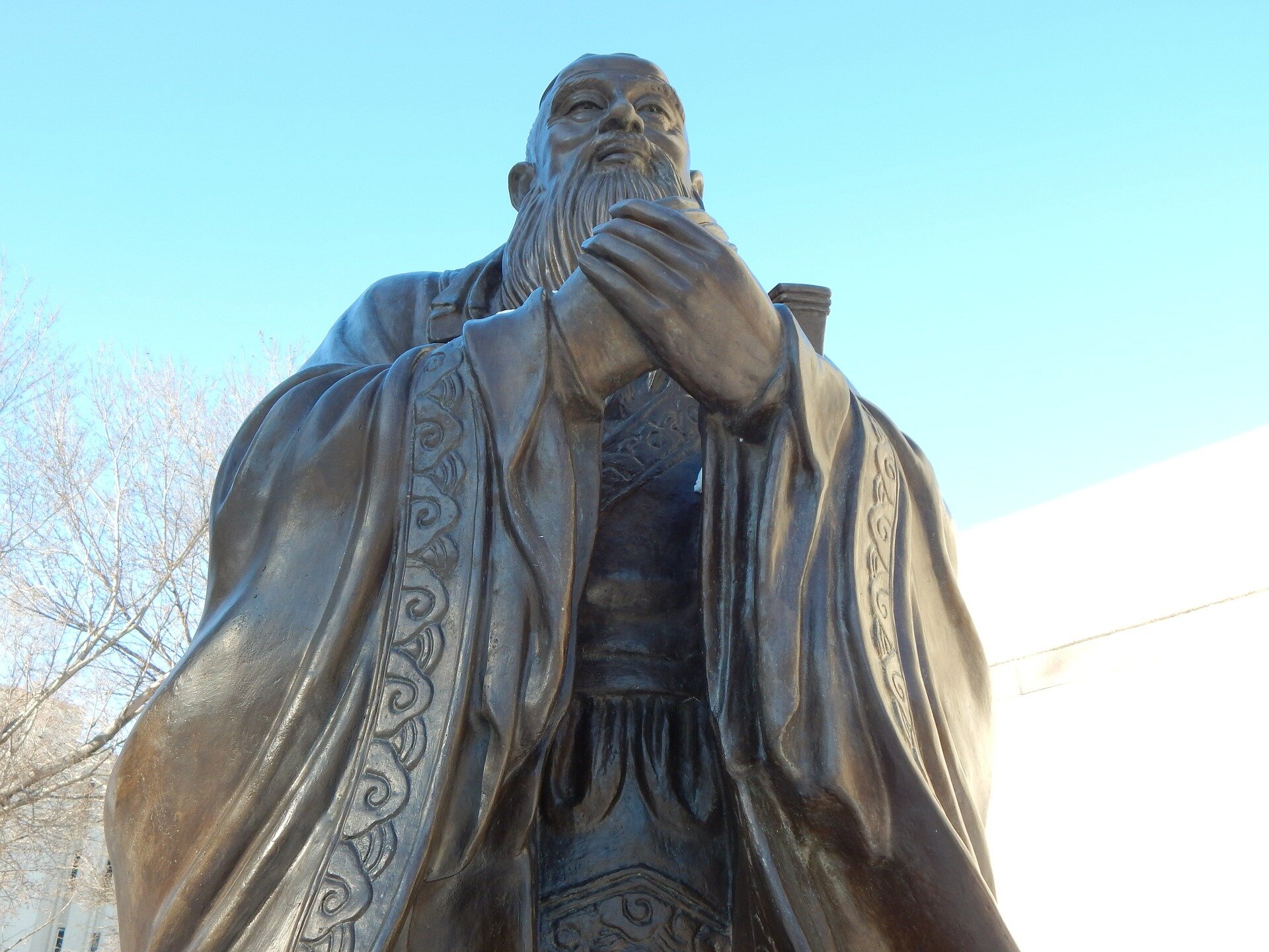Zdjęcie przedstawia posąg mężczyzny z długą brodą. Ma splecione dłonie. Ubrany jest w długą szatę.  