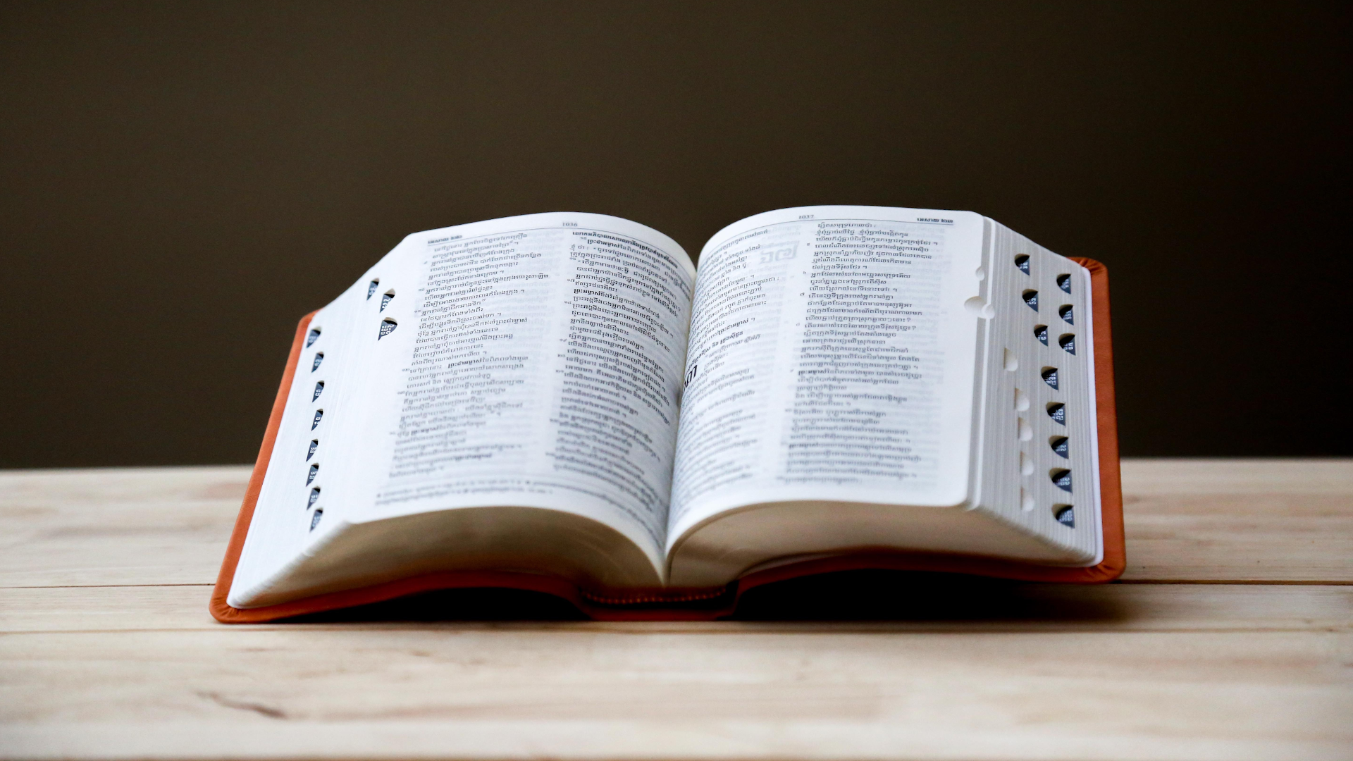 Zdjęcie przedstawia stół, na którym leży otwarty słownik.