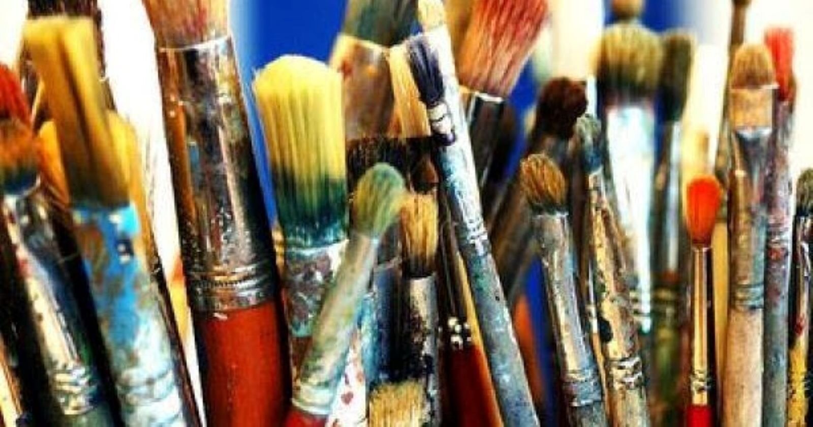 Zdjęcie przedstawia rząd starych pędzli malarskich. Były wielokrotnie używane, dlatego włosie jest starte i niedomyte, a na metalowej części trzonków pędzli są pozostałości farb.