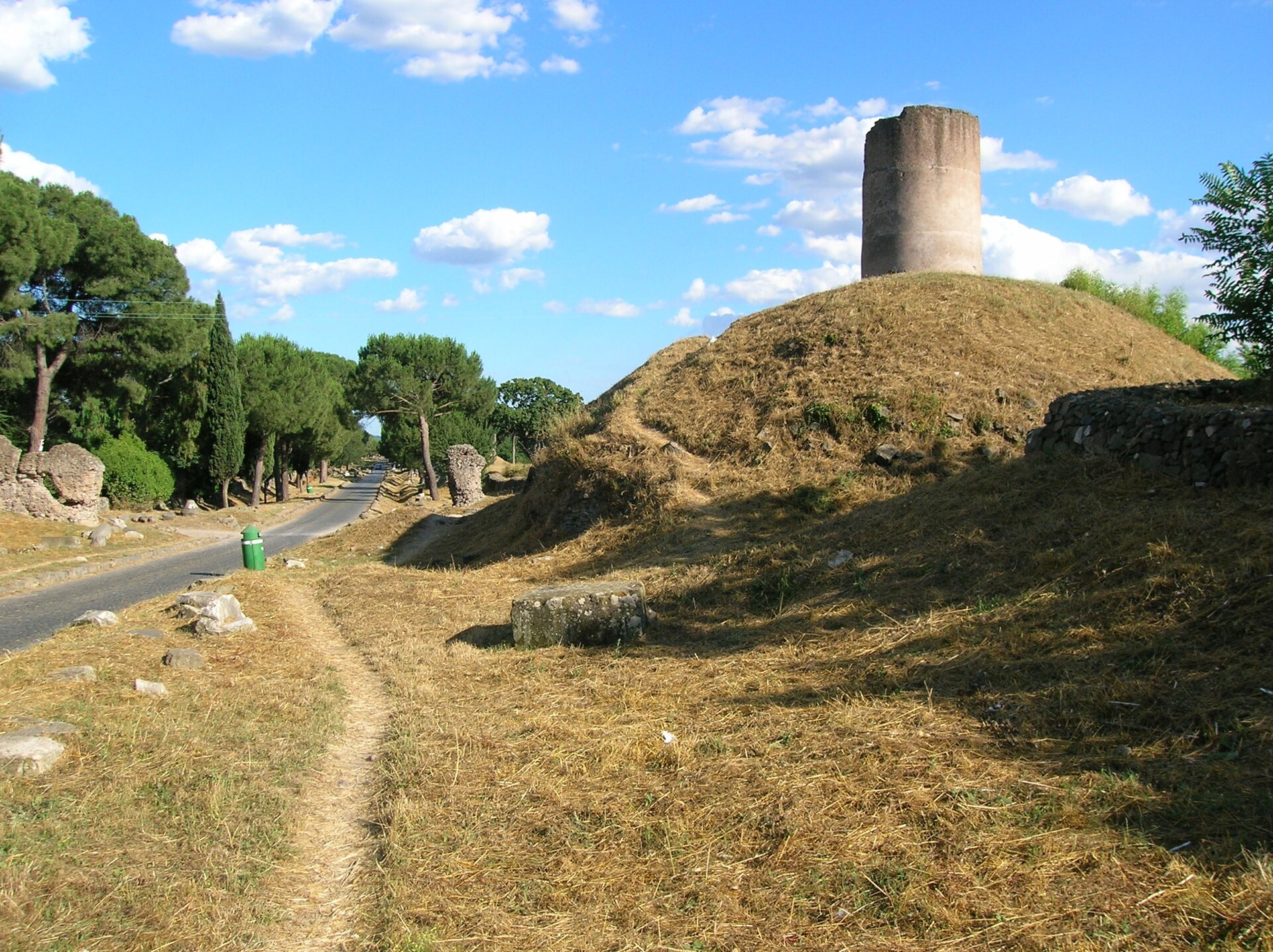 Ilustracja przedstawiająca legendarny grobowiec Kuracjuszy przy Via Appia. Ilustracja przedstawia okrągłą wieżyczkę stojącą na pagórku.