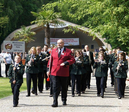 Zdjęcie przedstawia uliczny pochód orkiestry. 