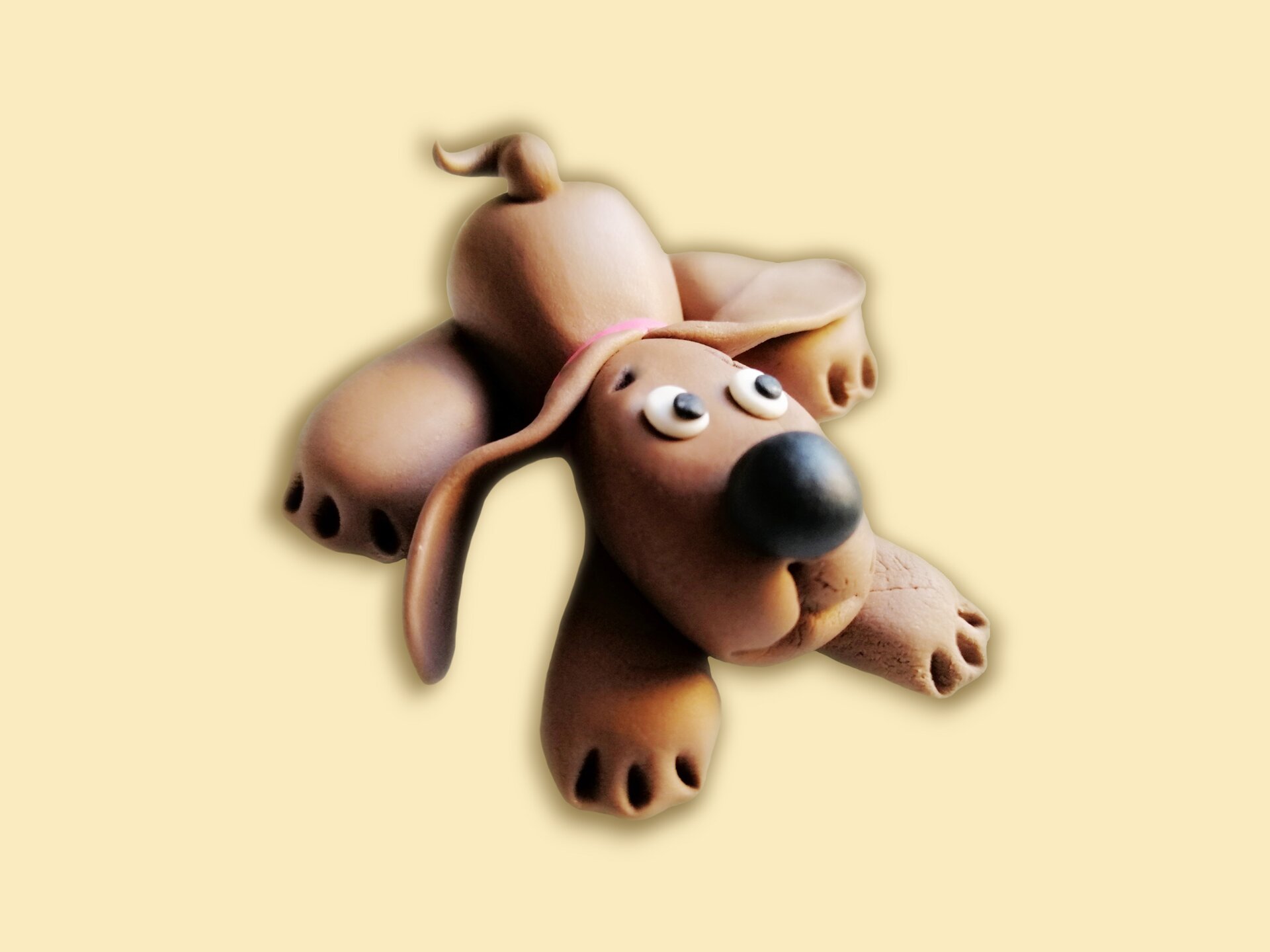 Figurka płasko leżącego psa z masy cukrowej.