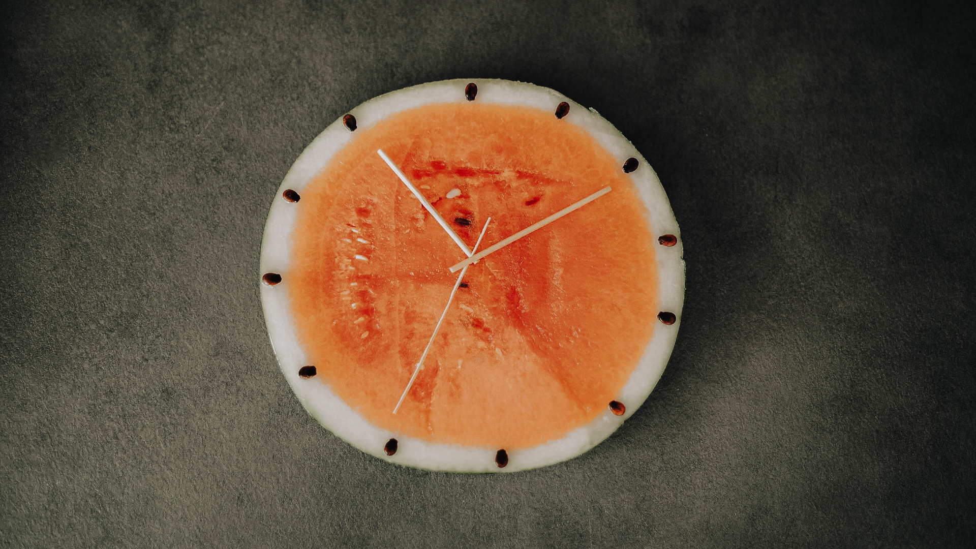 Zdjęcie przedstawia zegar utworzony z plastra arbuza.