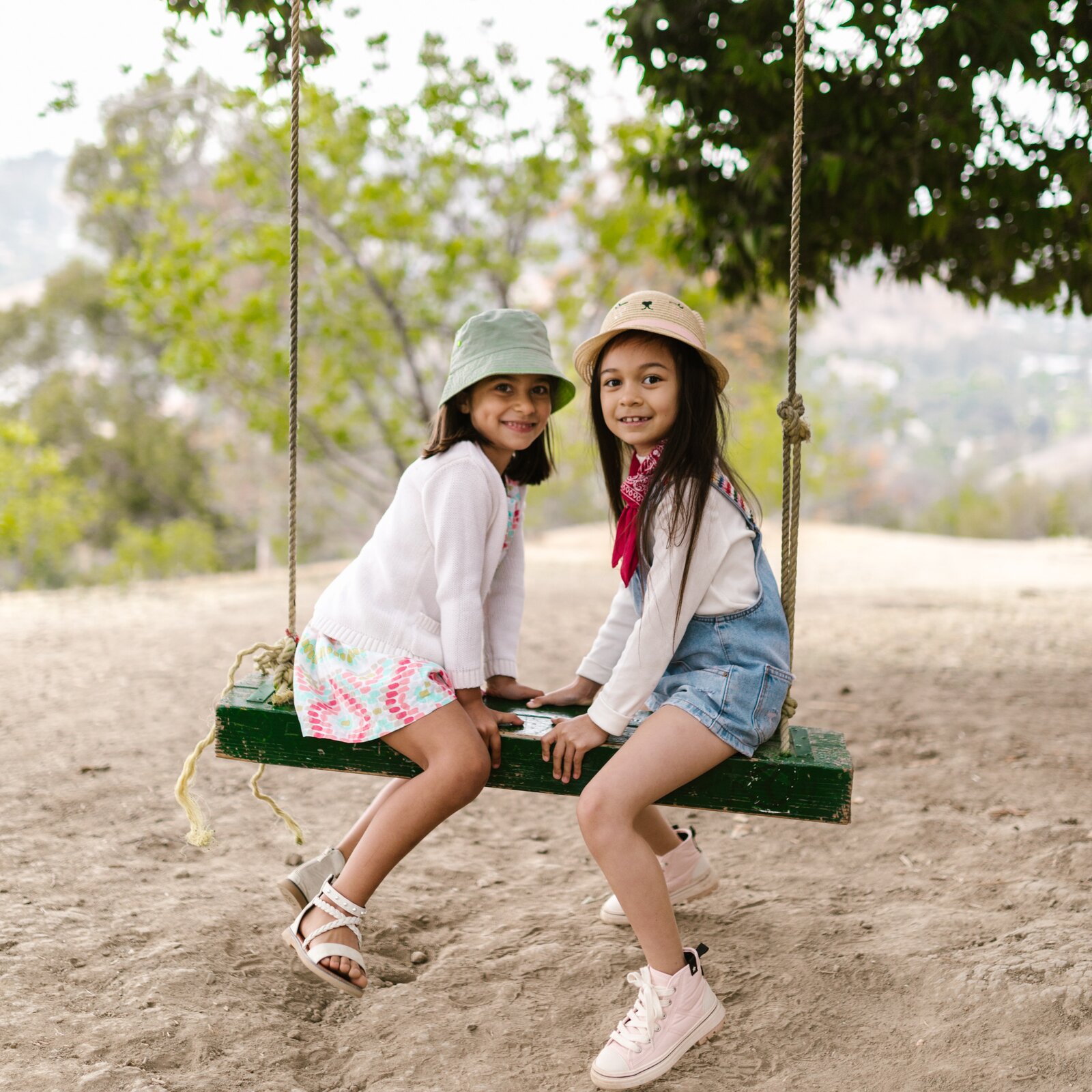 Ilustracja przedstawia dwie dziewczynki, które siedzą na huśtawce.