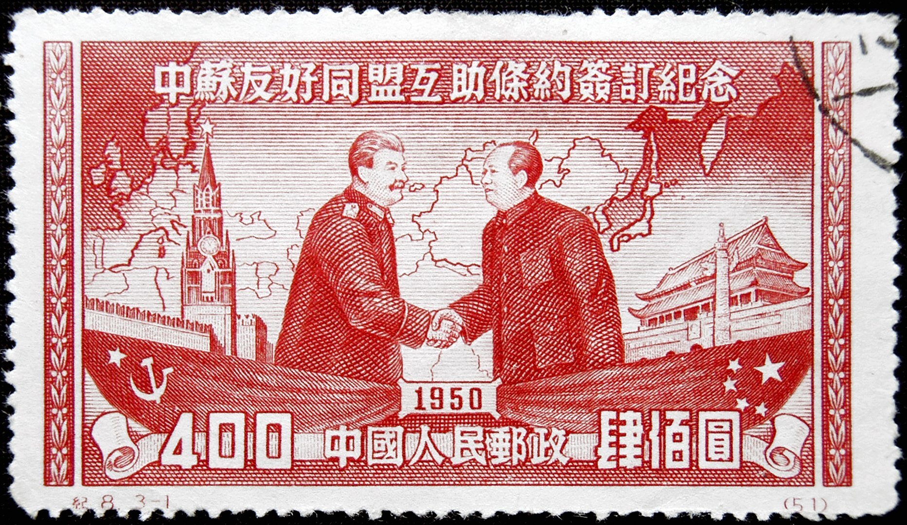 Ilustracja przedstawia znaczek pocztowy, na którym widać dwóch przywódców Mao Zedonga i Józefa Stalina podających sobie ręce. Mężczyźni stoją na dwóch łodziach. Jedna jest ze znakiem Chin, druga ze znakiem Związku Sowieckiego. Na górze jest napis w języku chińskim, na dole rok tysiąc dziewięćset pięćdziesiąty.