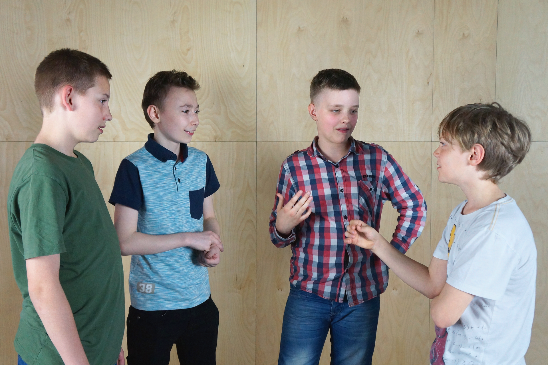 Galeria fotografii przedstawia etapy rozwoju człowieka od dojrzewania do starości. Fotografia przedstawia grupę czterech rozmawiających ze sobą chłopców w wieku około 12 lat.