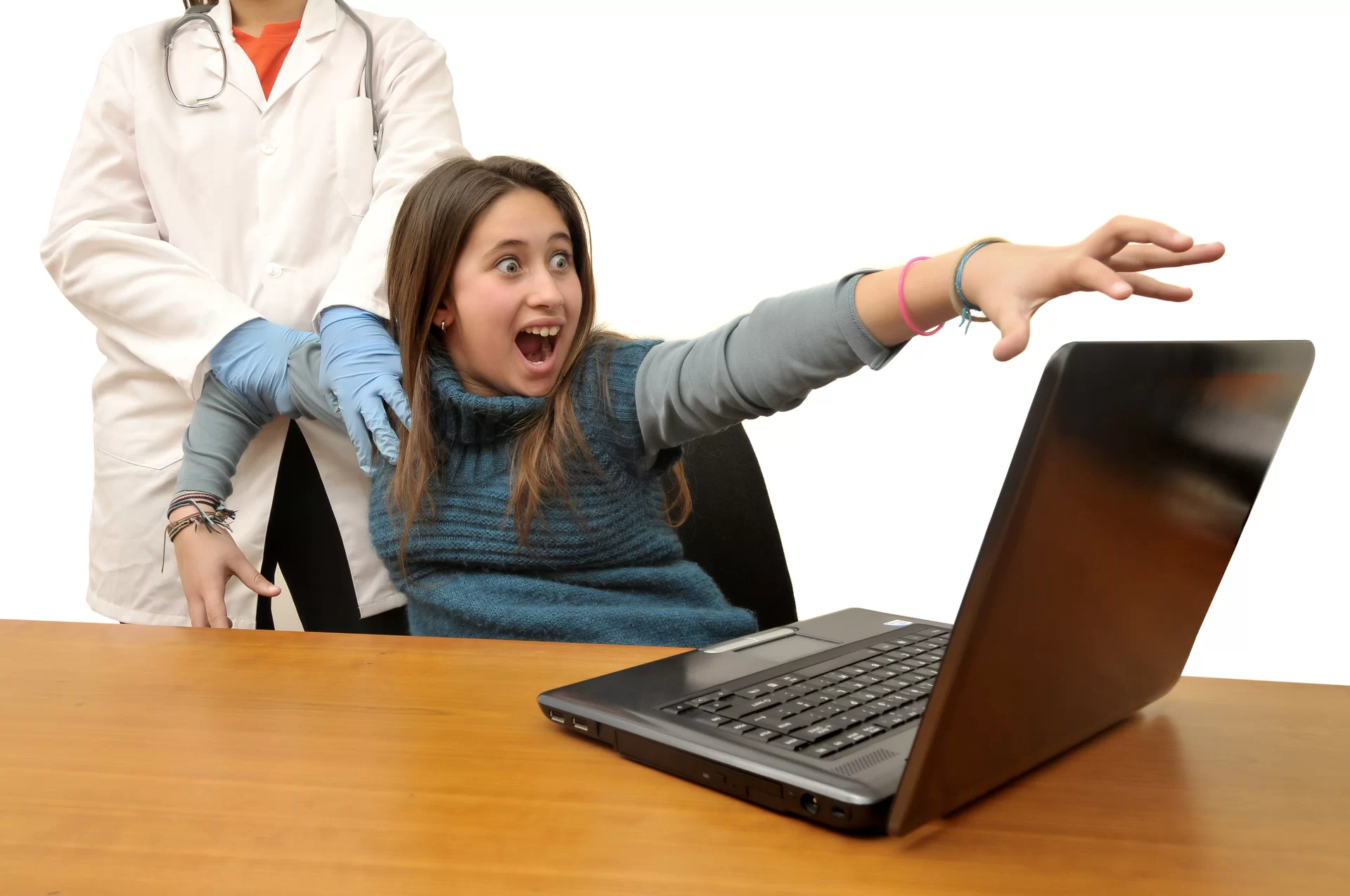 Ilustracja przedstawia uzależnienie od Internetu. Ukazuje młodą dziewczynę odciąganą od laptopa przez osobę w białym fartuchu i niebieskich, gumowych rękawiczkach. Dziewczyna ma przerażoną minę, krzyczy, lewą dłonią próbuje chwycić na ekran laptopa.