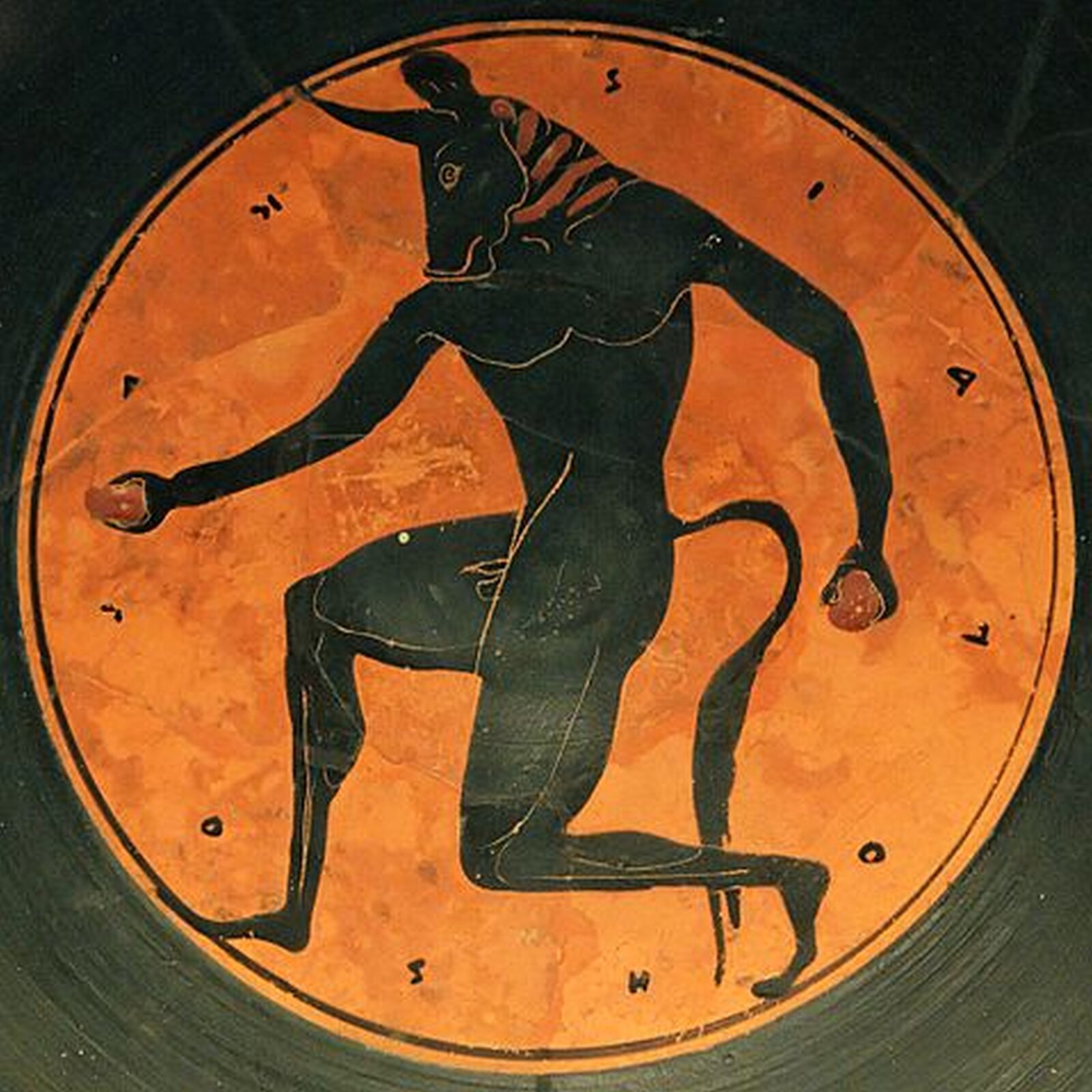 Ilustracja przedstawia czarnofigurowy medalion z kyliksu z wyobrażeniem Minotaura. Potwór ukazany jest na pomarańczowym tle. Ma męskie umięśnione ciało, ogon i głowę byka. W dłoniach trzyma kamienie.