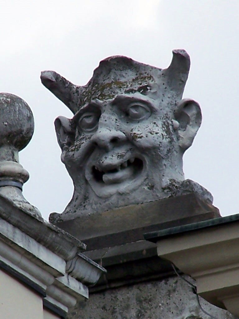 Na zdjęciu rzeźba stwora. Ma na głowie rogi. Ma wysunięty język.