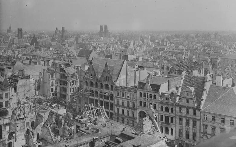 Zdjęcie przedstawia centrum Wrocławia z lotu ptaka. Widać liczne zniszczone od bombardowań i pożarów kamienice i inne budynki miejskie.