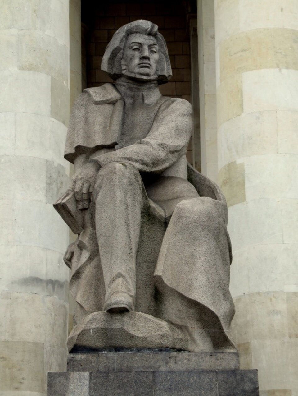 Rzeźba przedstawia siedzącego dumnie mężczyznę z dłuższymi włosami i brodą. Jest to Adam Mickiewicz. Mężczyzna trzyma książkę w lewej dłoni, którą trzyma na prawym kolanie.