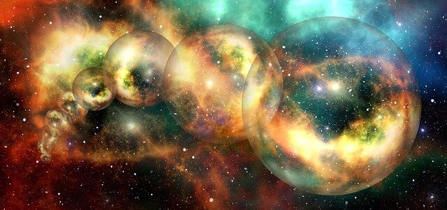 Zdjęcie ukazuje kosmos z kolorowymi mgławicami. Na ich tle są kule różnej wielkości, w których odbija się kosmos.   