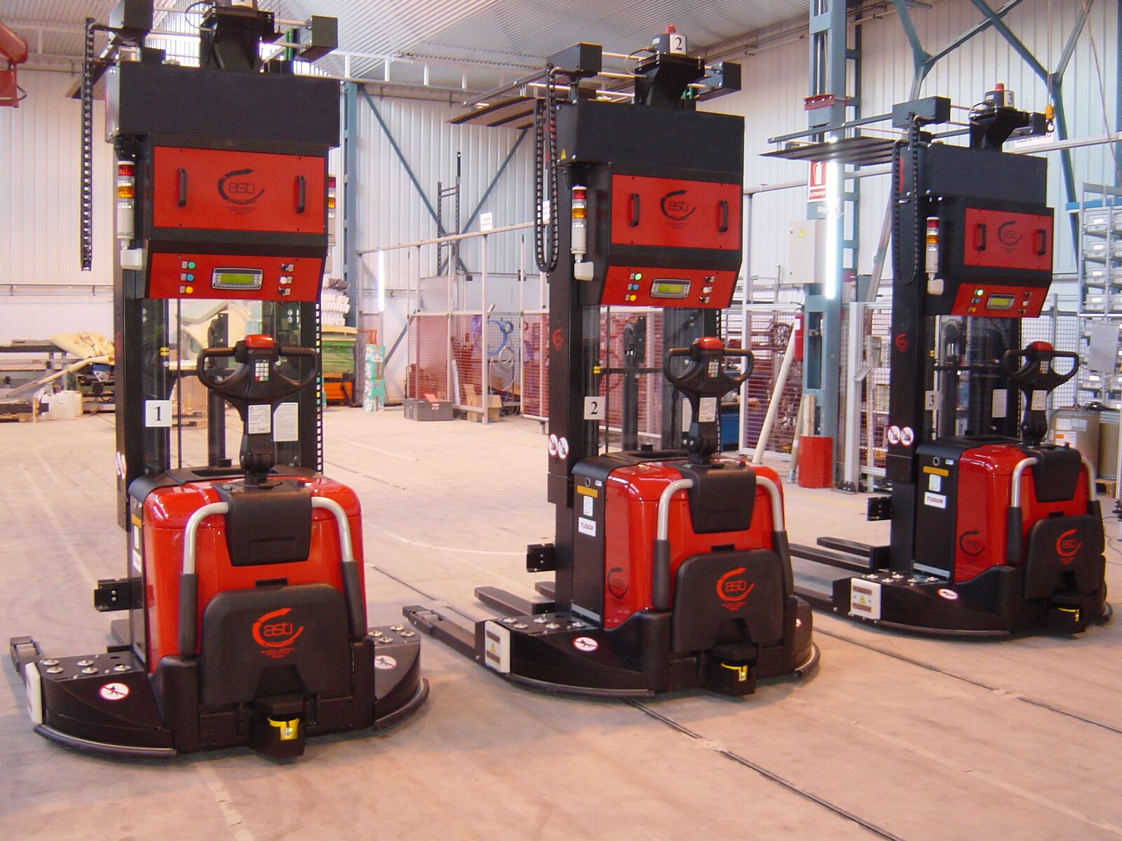 Na ekranie przedstawione trzy pojazdy sterowane automatycznie. Są to dość wysokie wózki, którymi steruje się automatycznie.