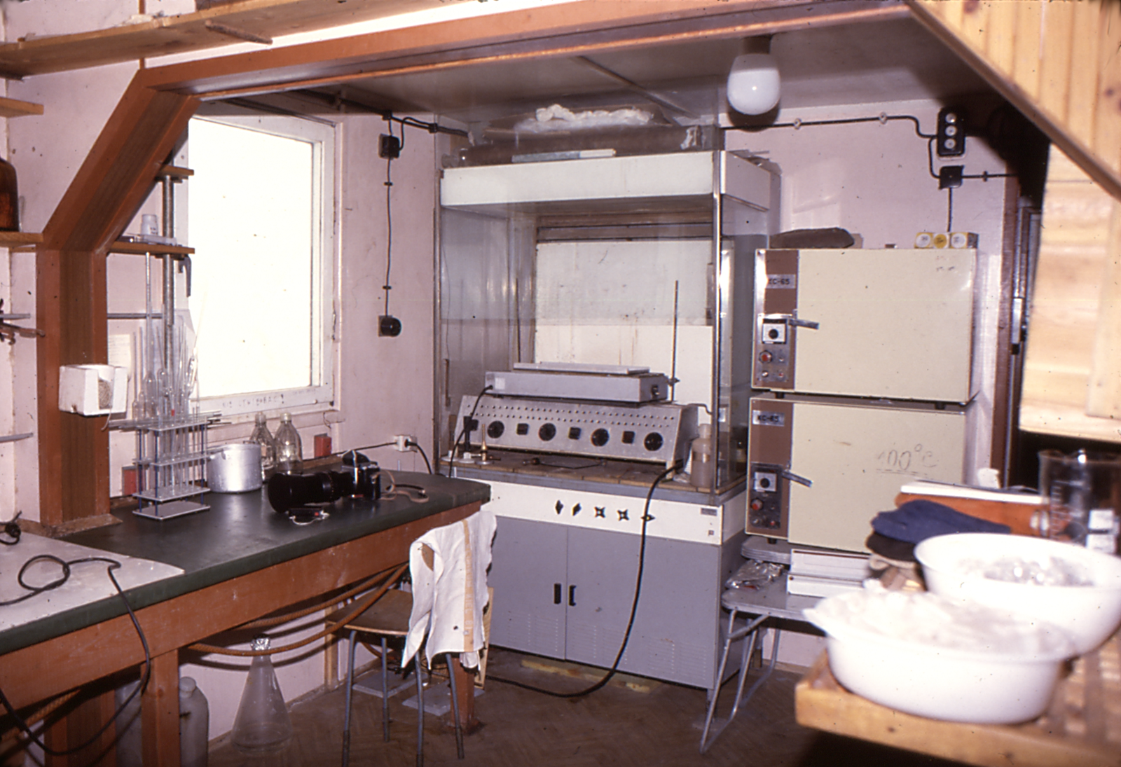 Zdjęcie przedstawia wnętrze laboratorium stacji badawczej. Na blatach i półkach sprzęt laboratoryjny i specjalistyczne urządzenia.