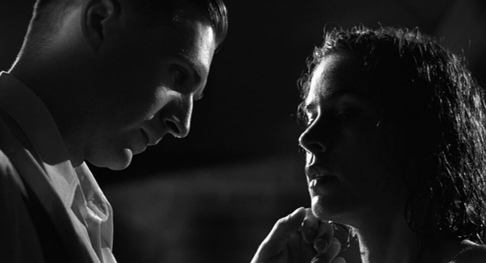 Zdjęcie przedstawia Götha stojącego naprzeciw młodej kobiety. Kobieta ma mokre włosy. Mężczyzna dotyka lewą dłonią podbródka kobiety. 