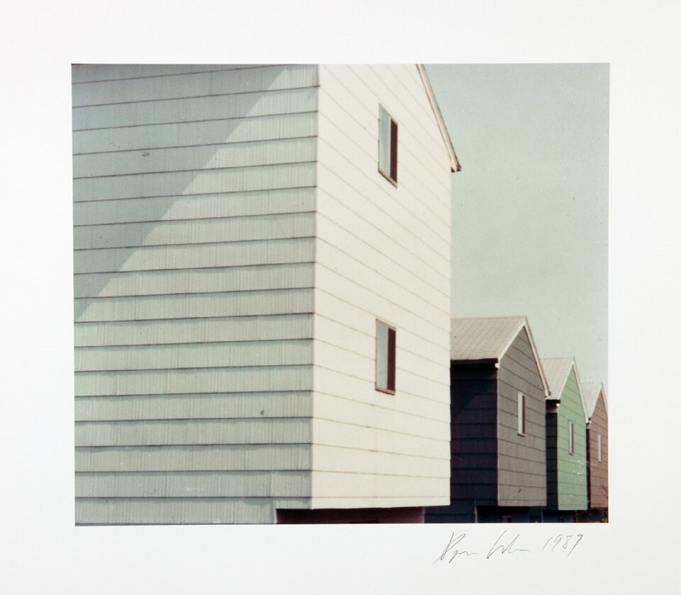 Ilustracja przedstawia fotografię Dana Grahama pt. „Homes for America”. Ukazuje ona cztery jednorodzinne domy, stojące w szeregu. Dom na pierwszym planie jest biały, kolejny fioletowy, następny zielony, a ostatni brązowy. Wszystkie domy mają białe dachy.