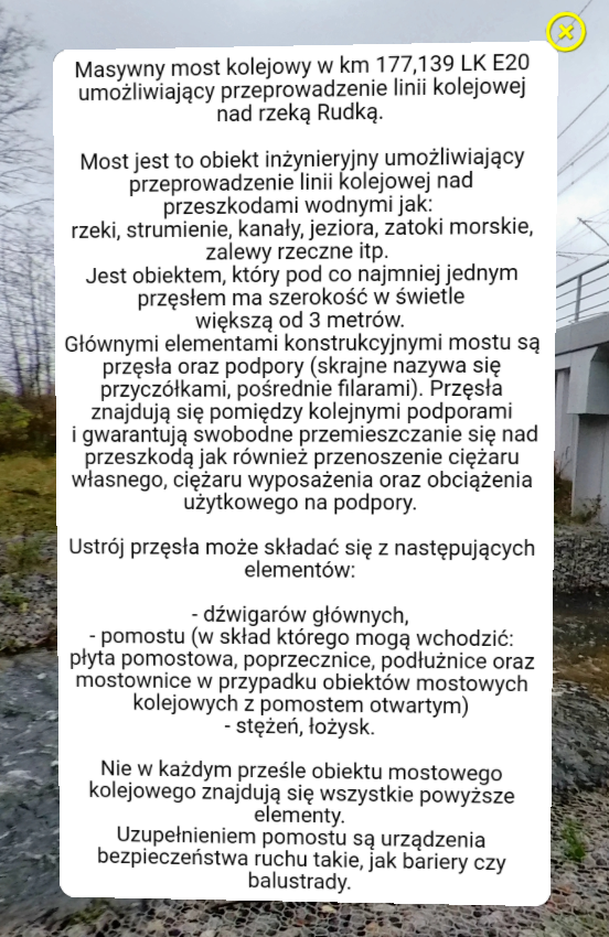 Przykładowy ekran z informacją w wycieczce. Widoczne jest białe okno z tekstem. W jego górnym prawym rogu znajduje się żółty krzyżyk.