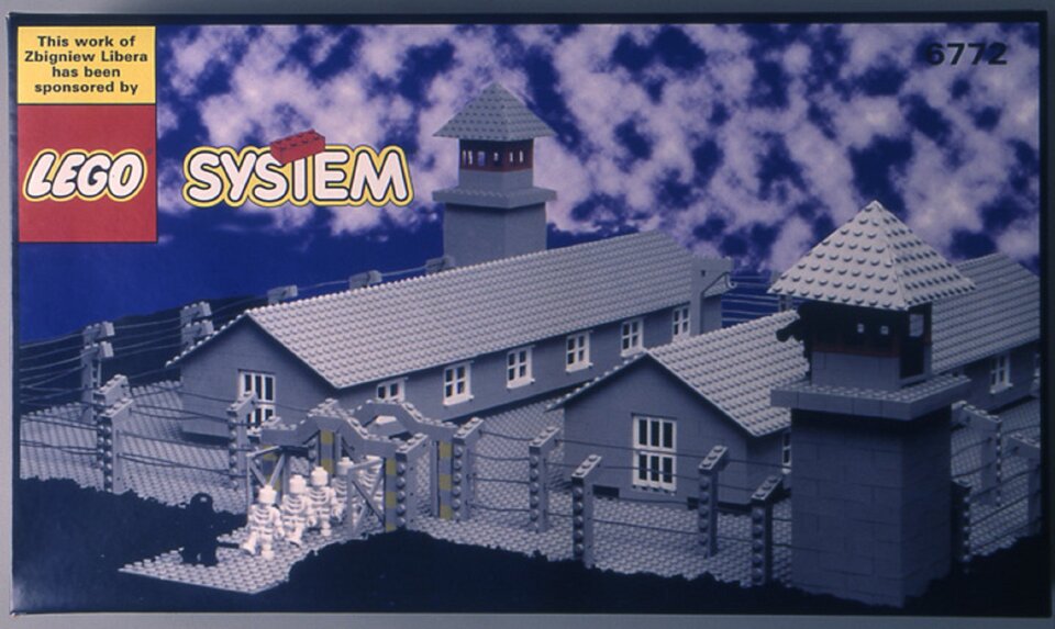 lustracja przedstawia pracę Zbigniewa Libera „LEGO. Obóz koncentracyjny”. Dzieło pochodzi z 1996 roku. Na fotografii widzimy prostokątne pudełko klocków LEGO. Znajduje się na nim rysunek budowli, jaka powstanie po złożeniu klocków. Jest to obóz koncentracyjny składające się z dwóch długich budynków. Na dwóch narożnikach znajdują się wysokie wieże. Całość ogrodzona jest płotem. Przed wejściem znajduje się kilka białych postaci oraz jedna czarna - strażnik. W lewym górnym rogu pudełka znajduje się napis This work of Zbigniew Libera has been sponsored by LEGO SYSTEM. Autorem pracy jest polski artysta, autor instalacji i wideoinstalacji, fotografik i performer. Libera zajmuje się także tworzeniem obiektów artystycznych