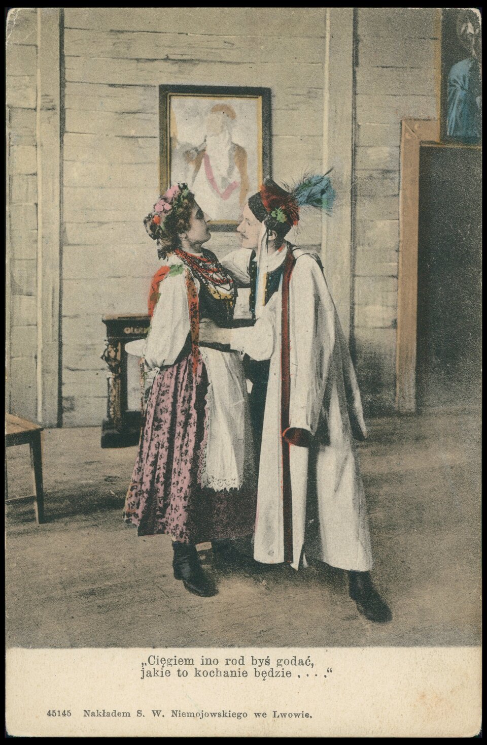 Ilustracja przedstawia parę, kobietę i mężczyznę w strojach ludowych. Mężczyzna obejmuje kobietę, a ta trzyma ręce za plecami. Mężczyzna ma narzucony na siebie płaszcz, na głowie ma czapkę z pawim piórem. Kobieta ma kwiecisty wianek we włosach i wzorzystą suknię z kwiecistym gorsetem i czerwonymi koralami. Za postaciami jest ściana z jasnych desek, na której wisi niewyraźny portret postaci w mundurze. Pod ilustracją jest napis: Cięgiem ino rod byś godać, jakie to kochanie będzie….