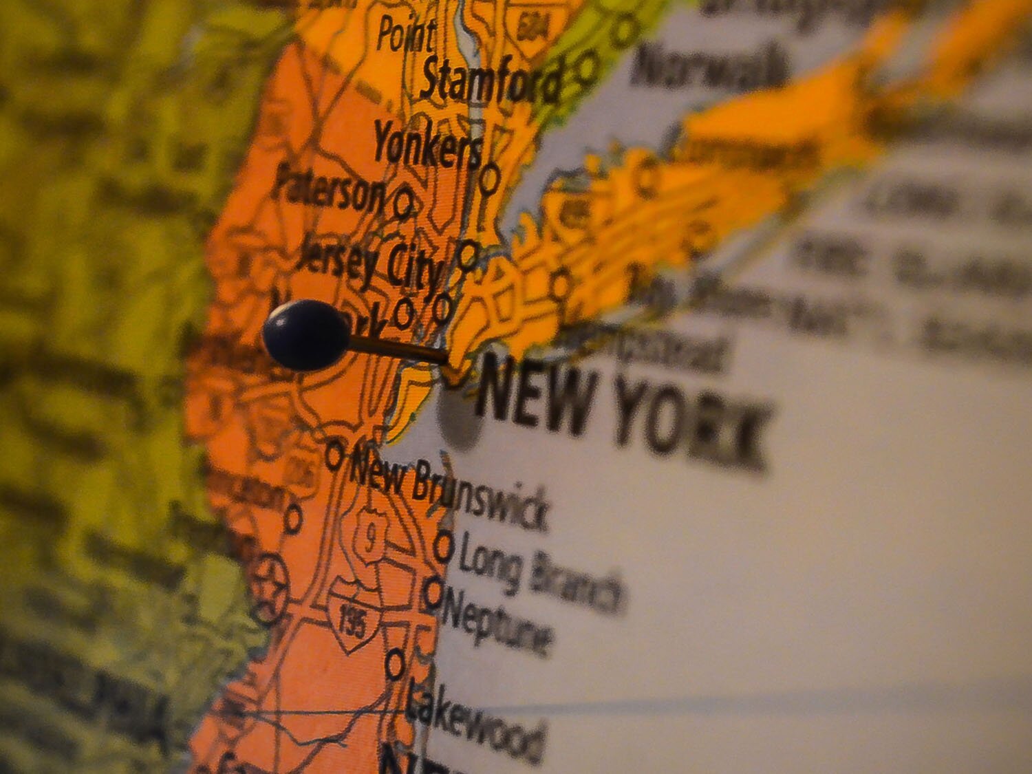 Zdjęcie przedstawia fragment mapy Stanów Zjednoczonych, a dokładnie wschodniego wybrzeża stanu Nowy  York. Na mapie widoczne są nazwy z miejscowości oraz wbita czarna pinezką wskazująca miasto Nowy  York. 