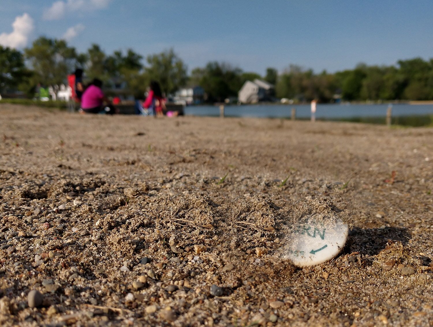 Zdjęcie przedstawia zdjęcie korka na ziemi.  Na korku widoczne są ubytki  i wydaje się być przezroczysty.