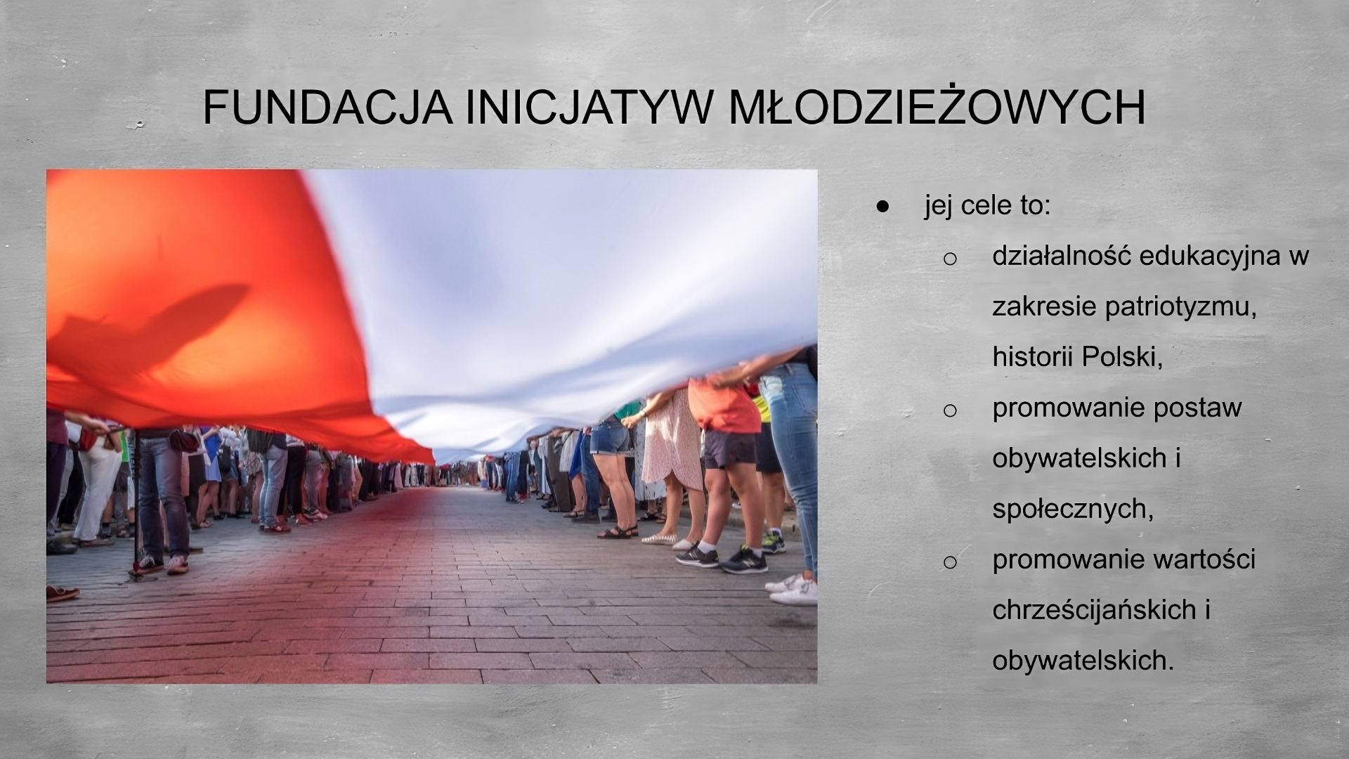 Slajd przedstawia szare tło, na górze tytuł: FUNDACJA INICJATYW MŁODZIEŻOWYCH. Po lewej stronie zdjęcie, u góry kadru rozciągająca się, trzymana przez ludzi, biało czerwona flaga (czerwony pas po lewej stronie, biały pas po prawej stronie), na dole kadru ceglany chodnik, po bokach widać nogi ludzi trzymających flagę. Po prawej stronie planszy wypunktowania: - jej cele to: - działalność edukacyjna w zakresie patriotyzmu historii Polski, - promowanie postaw obywatelskich i społecznych, - promowanie wartości chrześcijańskich i obywatelskich.