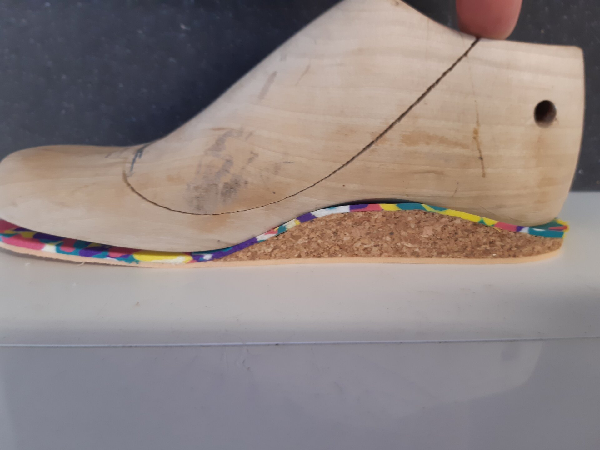 Zdjęcie przedstawia kopyto klinowe, do którego dopasowana została wkładka z płyty korkowej i pedilinu.