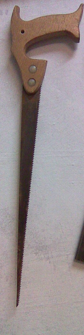 Zdjęcie przedstawia piłę otwornicę. Posiada ona drewniany uchwyt i metalową końcówkę do cięcia. Jest ona ząbkowana z jednej strony i zwęża się ku końcowi.