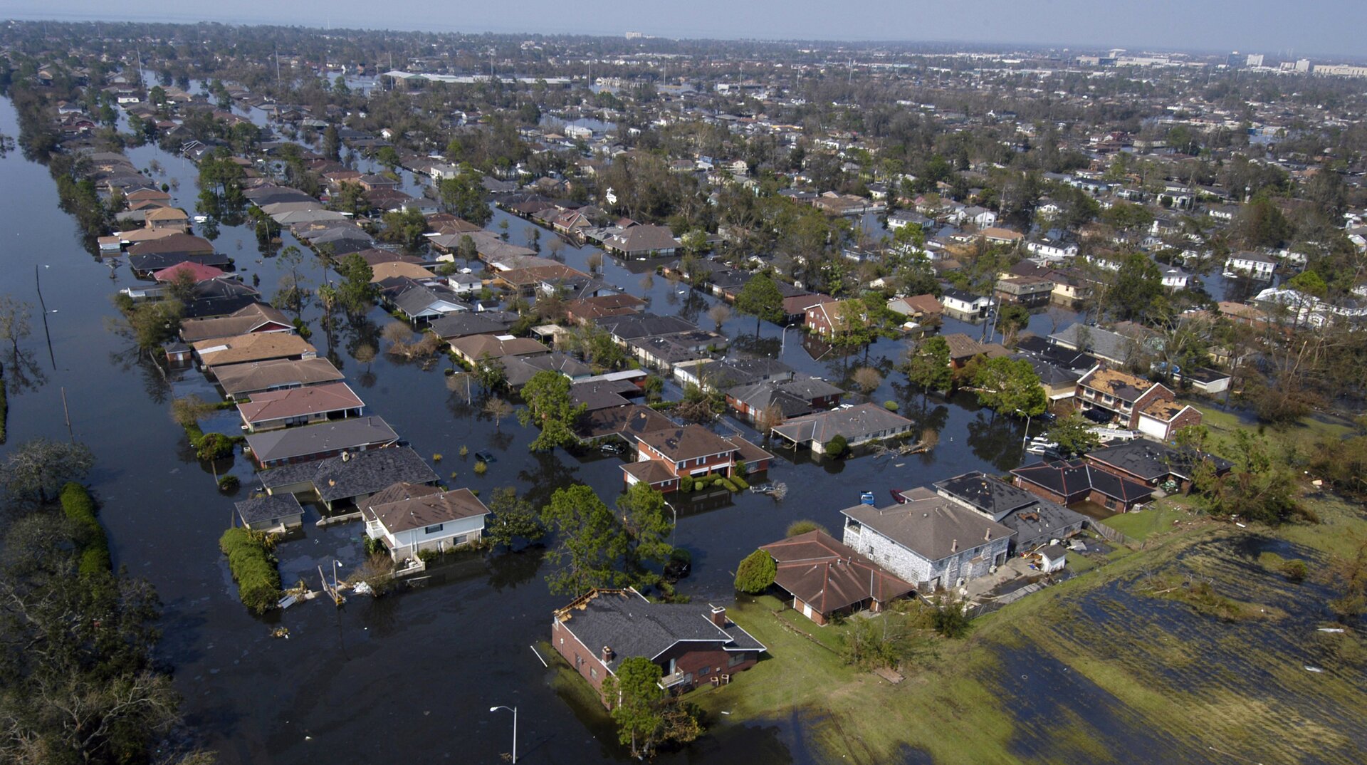 Zdjęcie przedstawia skutek huraganu Katrina. Budynki mieszkalne są otoczone wodą podchodzącą pod dachy.